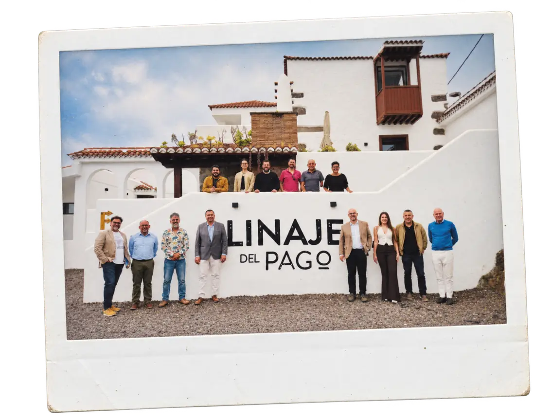 A group of people in front of the Linaje del Pago winery sign, in the Canary Islands.