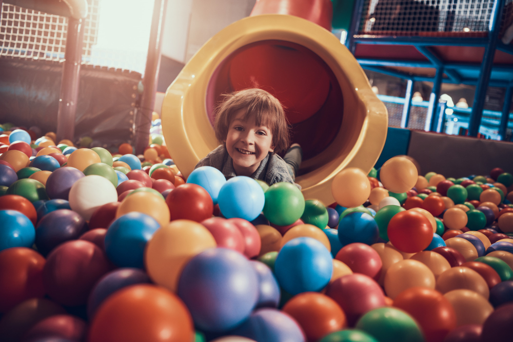 little boy lying pool full colorful balls